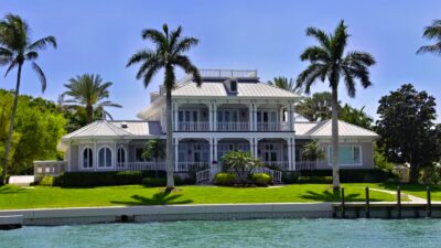 article01-heModern coastal luxury home exterior with palm trees, representing a Newport Beach area waterfront propertyro