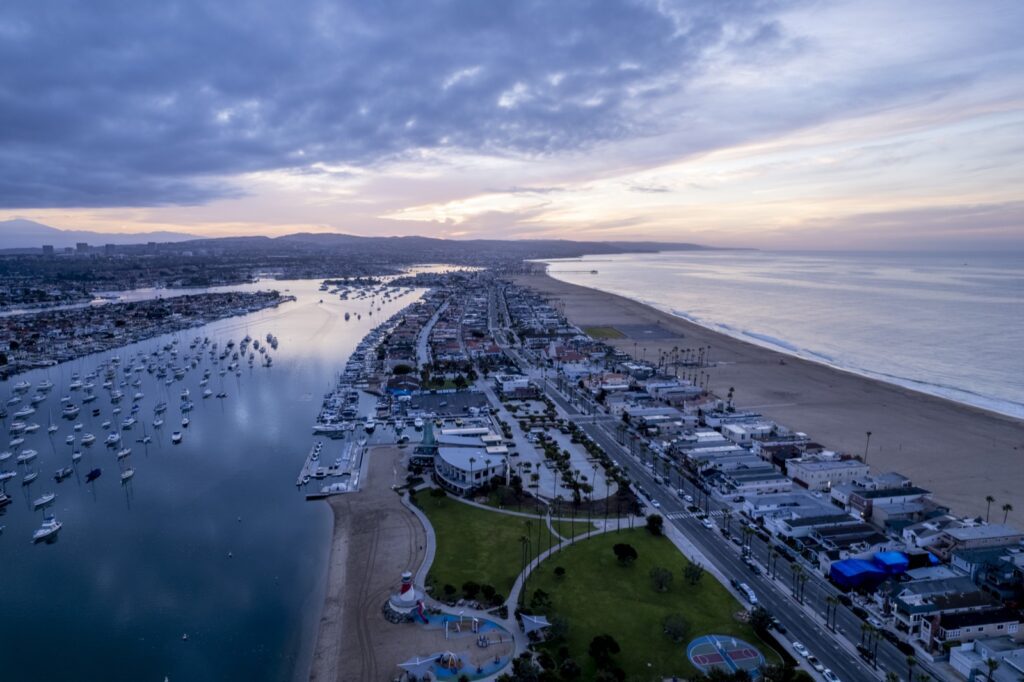 Aerial view of Newport Beach homes, the harbor and the Balboa Peninsula at sunset
