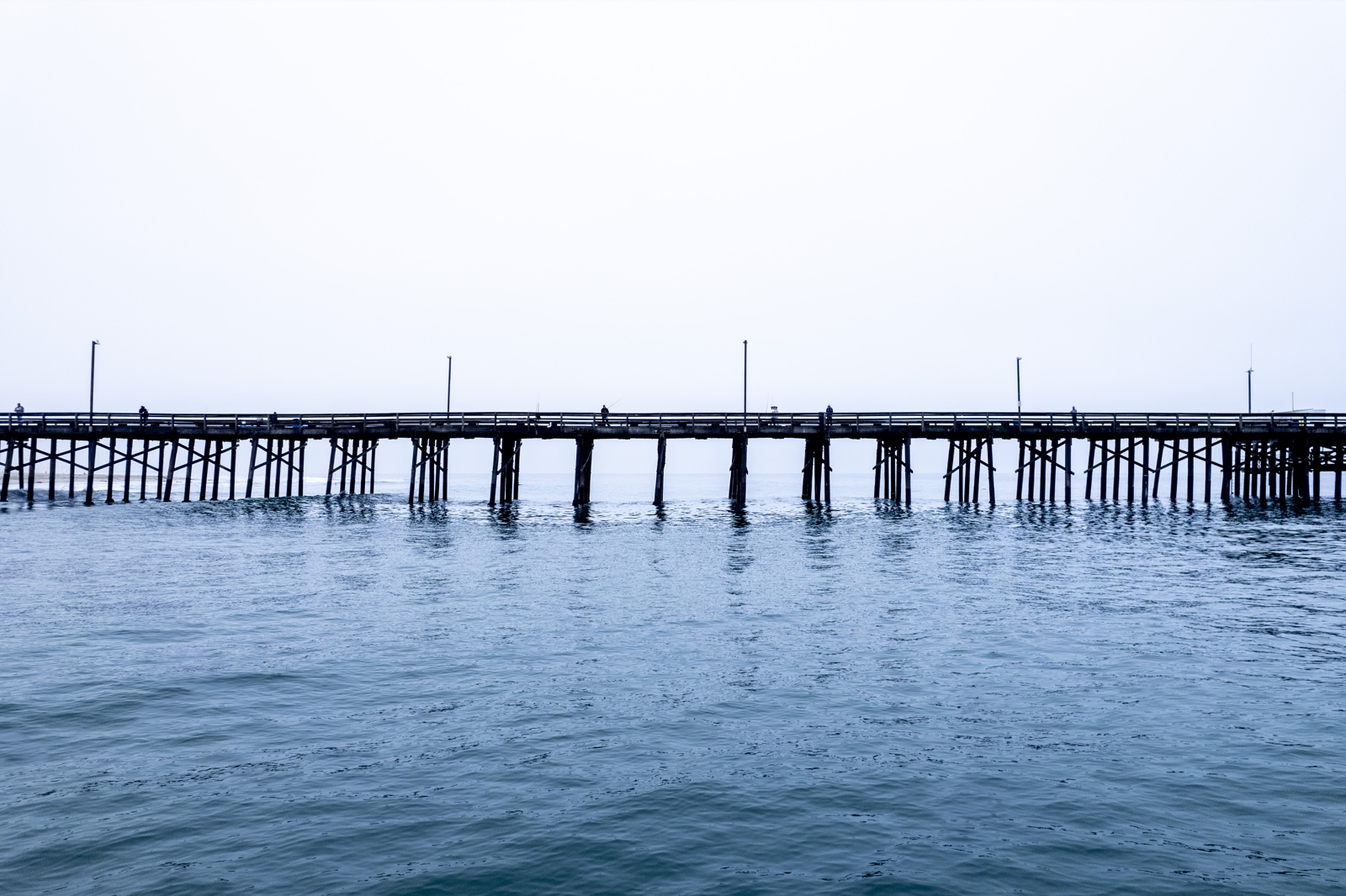 A wooden pier extending over the Pacific Ocean in Newport Beach, California